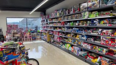 Bir perakende mağazasının içi müşterilerin bakması için oyuncak dolu raflarla doludur. Bina geniş ve renkli, uygun bir alışveriş deneyimi yaratıyor.