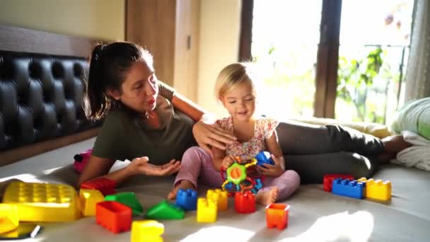 妈妈和小女孩在床上玩乐高积木 高质量的4K镜头 — 图库视频影像