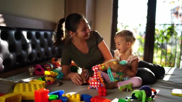 妈妈和小女孩坐在床上玩松软的玩具 高质量的4K镜头 — 图库视频影像