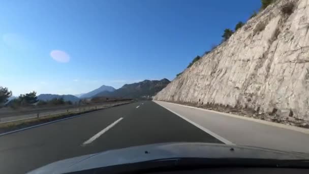 Auto Projíždí Asfaltové Dálnici Majestátními Horami Jako Pozadí Pod Oblohou — Stock video