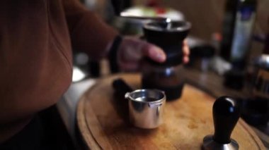 Adam masadaki kahve öğütücüsünde kahve öğütüyor, kolu çeviriyor. Yüksek kalite 4k görüntü