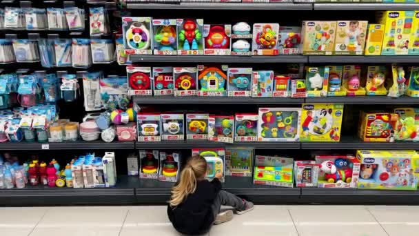 Клієнт Сидить Підлозі Роздрібному Магазині Вивчаючи Продукти Полиці Наповненій Іграшками — стокове відео