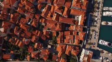 Kırmızı tuğlalı binaları, limanı ve bitkisel manzarası olan bir şehrin havadan görünüşü. Kentsel tasarım, kırmızı çatılar ve tuğla işçiliğinin güzel bir karışımını içeriyor.