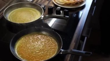 Aşçı tavada portakal sosu kaynayan sobanın yanında duruyor. Yüksek kalite 4k görüntü