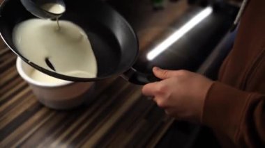 Şef hamuru tavaya döker ve dağıtmak için döndürür. Yüksek kalite 4k görüntü