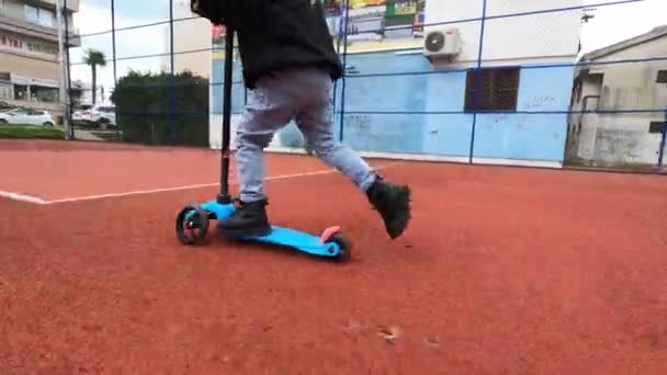 Menino Está Rolando Uma Scooter Azul Com Uma Única Roda — Vídeo de Stock