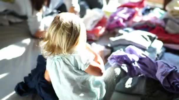 Küçük Kız Annesiyle Birlikte Yatağın Üzerindeki Çamaşır Yığınının Arasında Oynuyor — Stok video