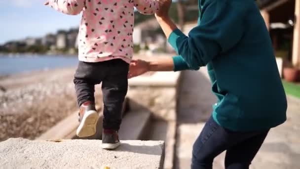 Мама Подбирает Маленькую Девочку Идущую Вдоль Забора Окружает Высококачественные Fullhd — стоковое видео
