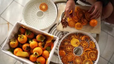 Annem meyve kurutma tepsilerine hurma parçaları koyar ve küçük bir kız gelip bir parça alır. Yüksek kalite 4k görüntü