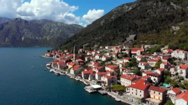 Arka planda dağlar olan, gölün yanında küçük bir kasaba. Hava manzarası güzel bir doğal manzaraya yuva yapmış binaları, evleri ve yeşillikleri gösteriyor.