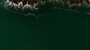 Yeşil dalgalar kayalarda köpürüyor. Üst Manzara. Yüksek kalite 4k görüntü