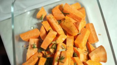 Cam bir tabakta biberiye ve değirmenin baharatlarıyla tatlı patates parçaları pişir. Yüksek kalite 4k görüntü