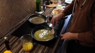 Aşçı tavalara portakal suyu ekliyor ve spatulayla karıştırıyor. Yüksek kalite 4k görüntü