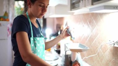 Önlüklü bir ev kadını elektrikli et öğütücüsünün tepsisine et koyar ve kıyma yapar. Yüksek kalite 4k görüntü