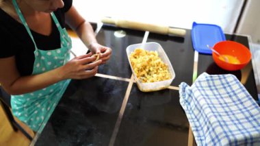 Ev hanımı masada oturan içi doldurulmuş çörekleri kapatıyor. Yüksek kalite 4k görüntü