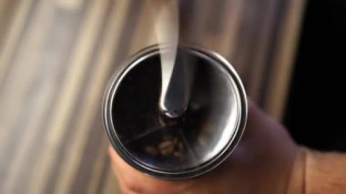 Barmen, kahve çekirdeklerini manuel kahve öğütücüsünde hızla çevirerek öğütüyor. Yüksek kalite 4k görüntü