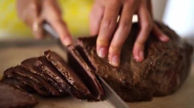 Ev hanımı bifteği kesme tahtasına koyup parçalara ayırıyor. Yüksek kalite 4k görüntü