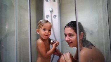 Annem ve küçük bir kız duşta yıkanıyor. Yüksek kalite 4k görüntü