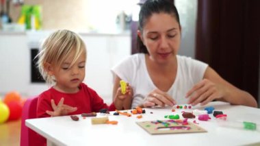 Anne ve küçük bir kız çok renkli plastik toplar yontuyorlar. Yüksek kalite 4k görüntü