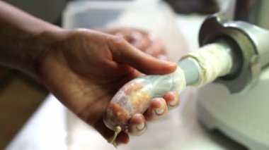 Aşçı et öğütücüsünün hortumunun bağırsağını kıyma ile doldurur. Yüksek kalite 4k görüntü