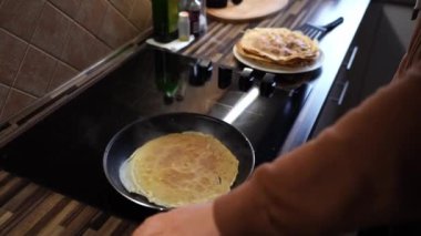 Aşçı tavadan bir krep alıyor ve tabağa koyuyor. Yüksek kalite 4k görüntü