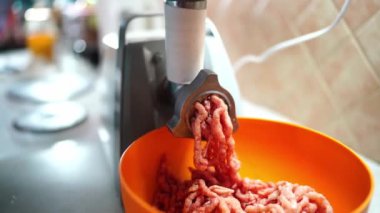 Pembe kıyma şeritleri elektrikli et öğütücüsünün değirmen taşlarından çıkarak derin bir kaseye dönüşür. Yüksek kalite 4k görüntü