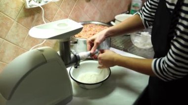 Aşçı, sosisi elektrikli et öğütücüsünün hortumuna doldurduğu için bağırsağı çeker. Yüksek kalite 4k görüntü