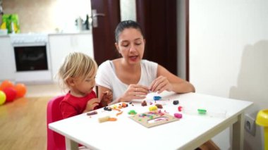 Anne küçük bir kıza plastik figürlerin nasıl yontulduğunu gösteriyor ve anlatıyor. Yüksek kalite 4k görüntü