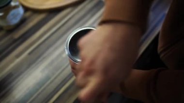 Barmen kahve çekirdeklerini öğütürken manuel kahve öğütücüsünün sapını çeviriyor. Yüksek kalite 4k görüntü