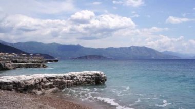 Deniz dalgaları kumsalda yuvarlanır ve taştan dalgalar akar. Yüksek kalite 4k görüntü