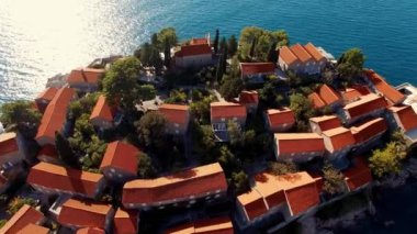 Suyla çevrili küçük bir adadaki küçük bir kasabanın hava görüntüsü, eşsiz şehir tasarımı, ağaçlı sokaklar ve renkli cepheli büyüleyici binalar.