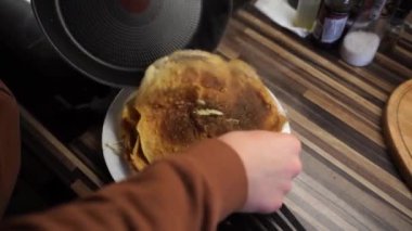 Aşçı gözlemeyi tavadan çıkarır ve eliyle tabağa götürür. Yüksek kalite 4k görüntü