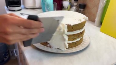 Bir spatula kullanarak, kişi bir tabağa yerleştirilmiş şekerli kekin üzerine şekerleme yayıyor. Bu tatlı her durum için mükemmel ve son yemek çok lezzetli görünüyor.