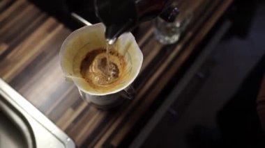 Barista, metal testiden kahve makinesinin üzerine su döküyor. Yüksek kalite 4k görüntü