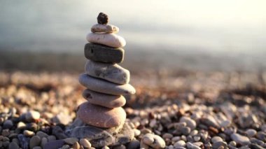 Kumlu plajda duran bir yığın kaya doğal manzaraya karşı çarpıcı bir denge oluşturuyor. Her çakıl taşı özenle yerleştirilmiş eşsiz bir yapı oluşturur.