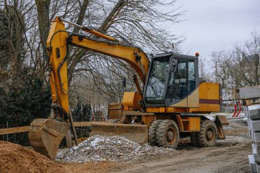 Bulutlu bir günde inşaat alanında bıçak ve boru ile modern kazıcı. Yüksek kalite fotoğraf