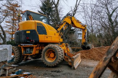 Bulutlu bir günde inşaat alanında bıçak ve boru ile modern kazıcı. Yüksek kalite fotoğraf