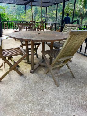 Bahçede bir masa ve sandalyeler var. Yeşil dağ binası. 