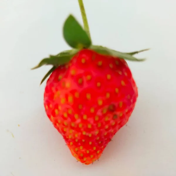 赤いイチゴの果実緑が白い背景を残し — ストック写真