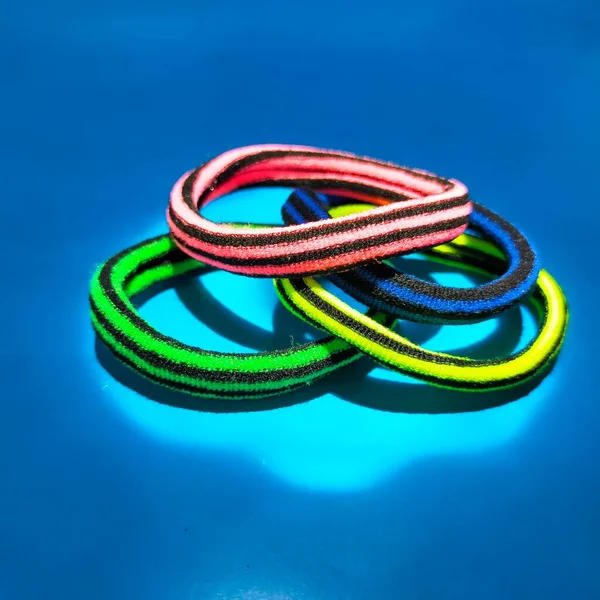 Green Hair Tie Red Yellow Blue Background — Stock Photo, Image