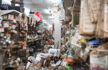 Sel baskınlarından, sergilenen raflardan ve çamur ve molozlarla kaplı ürünlerden ağır şekilde etkilenen bir perakende mağazası. Ürünler düzensiz, çoğu zarar görmüş ve yerinden edilmiş, dağınık ve kaotik bir çevreye sahip. Mağaza, bir insanın neden olduğu yıkımı yansıtıyor.