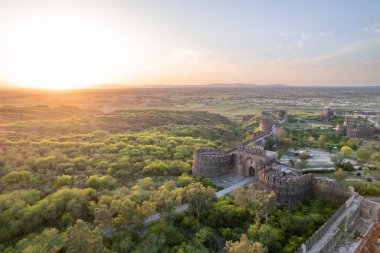 Gün batımında yeşil tepelerin tepesindeki Rohtas kalesinin güzel manzarası. Eski, eski, tarihi, eski Hint / Pakistan kalesinin kalıntıları..