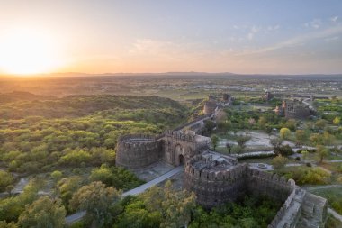 Gün batımında yeşil tepelerin tepesindeki Rohtas kalesinin güzel manzarası. Eski kalenin kalıntıları. Antik Hint tarihini, mirasını ve mimarisini gösteriyor..