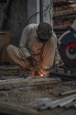 Zavallı Pakistanlı kaynakçı boruları ve sokak atölyesindeki metal çubuklar.