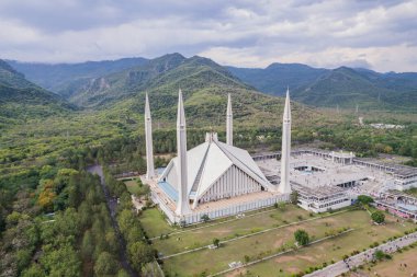 Faisal Camii İslamabad Pakistan 'ın havadan görünüşü. Arkaplanda yeşil bulutlu Margala tepeleri.