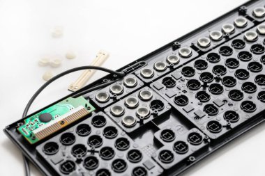 Tamir, klavyeyi temizlemek. siyah klavye, plastik beyaz kapaklar, mikro devre. klavye ayrıntıları.