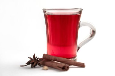 Bir bardak kırmızı sıcak içecek (çay, sıcak şarap, punç). Kışın sıcak içecekler için malzemeler.