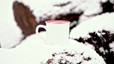 Tozlu kar, karla kaplı odunlarda bir fincan sıcak içecek..