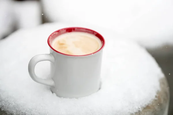 mug with coffee in the snow. winter. snowfall.