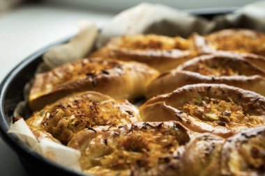 Annem evde yemek pişiriyor. Lahanalı çörekler fırın tepsisinde.